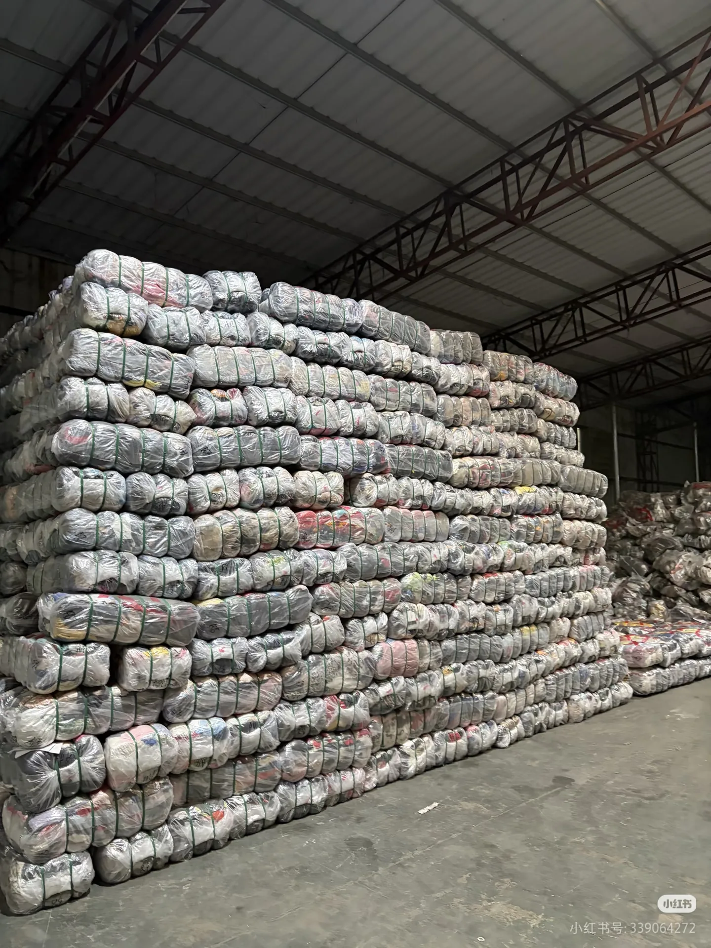 used clothes in bulk stacked bales supplier warehouse